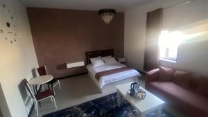 ein Hotelzimmer mit einem Bett und einer Couch in der Unterkunft Madani in Arys