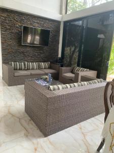 eine Terrasse mit 2 Korbsofas und einem TV in der Unterkunft EL MILAGRO FINCA VACACIONAL in San Rafael