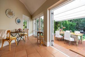 an open dining room with a table and chairs at Villa Puccini in Cape Town