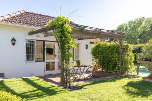 a pergola with a table in a yard at Villa Puccini in Cape Town