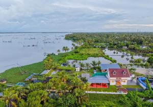 an aerial view of a house on an island in the water at Celestiah Lakeshore Kochi by VOYE HOMES - Peaceful Backwater Stay in Kumbalangi in Cochin +54 photos