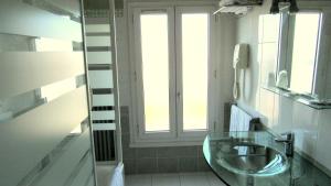 a bathroom with a glass sink and a window at Hôtel du Square d'Anvers in Paris