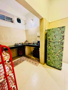 una cocina con una puerta verde y una silla roja en The Divine Abode Homestay, en Guwahati 4 fotos más