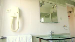 a bathroom with a glass sink and a mirror at Hôtel du Square d'Anvers in Paris