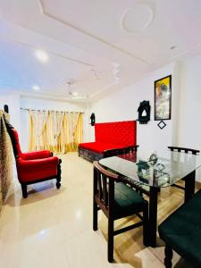 Una sala de estar con un sofá rojo y una mesa. en The Divine Abode Homestay, en Guwahati