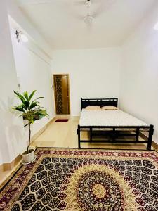 un dormitorio con una cama y una alfombra en The Divine Abode Homestay, en Guwahati