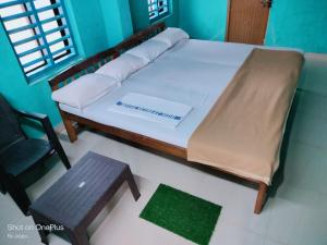 Cama en habitación con silla y banco en Totadamane in murdeshwar, en Bhatkal 8 fotos más