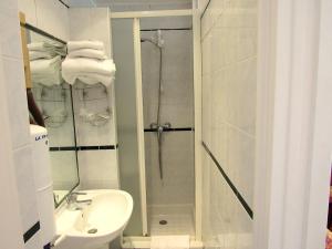 a bathroom with a shower and a toilet and a sink at Hôtel du Square d'Anvers in Paris