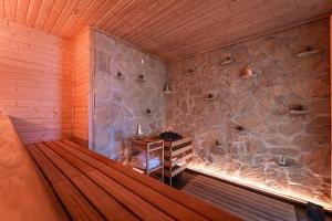 a room with a table in a room with a stone wall at Elements Apartments & Renata in Božičany +118 photos