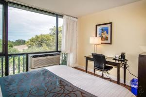 a bedroom with a bed and a desk and a window at Red Lion Hotel Monterey in Monterey