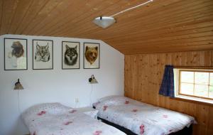 a bedroom with two beds and pictures of cats on the wall at Lillvikens Gästhuset och Stugor in Nedre Lillviken