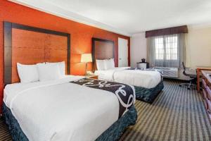 two beds in a hotel room with orange walls at Chicago O'Hare Airport in Elk Grove Village +13 photos