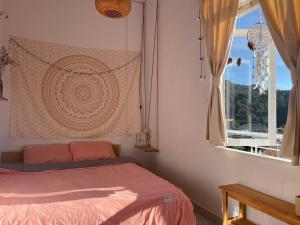a bedroom with a bed and a window at Roxie home view thung lũng,săn mây, gần trung tâm in Xuan An