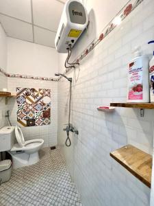 a bathroom with a toilet and a camera on the wall at Roxie home view thung lũng,săn mây, gần trung tâm in Xuan An