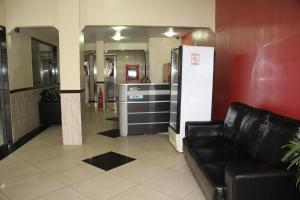 a waiting room with a couch and a refrigerator at Comfoort Hotel in Volta Redonda