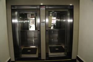 two elevators in a building with their doors open at Comfoort Hotel in Volta Redonda