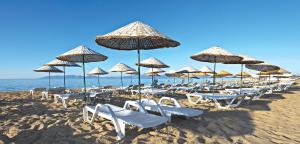 a bunch of chairs and umbrellas on a beach at Studio Baturcan in Ayvalık