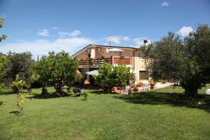 a building with a yard with trees in front of it at La Collina del Riccio in Ortona
