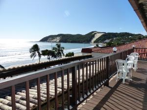 balcón con 2 sillas y vistas a la playa en Hotel Pousada Azzurra, en Natal