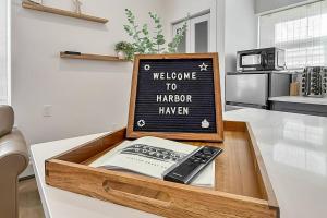 a wooden tray with a book and a remote control in a kitchen at Harbor Haven, Apt #1 - Studio in Stamford