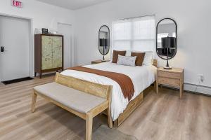 a bedroom with a large bed and two mirrors at Harbor Haven, Apt #1 - Studio in Stamford