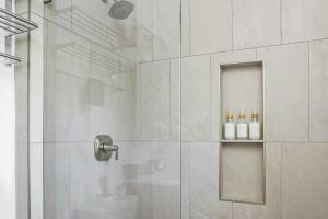 y baño con ducha y 2 botellas en un estante. en Harbor Haven, Apt #1 Studio, en South End 41 fotos más