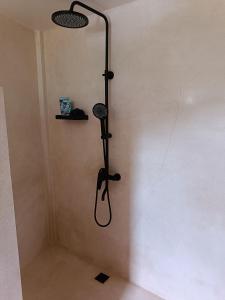 a shower in the corner of a room at Sonnenhouse Lombok Kertaraharja in Luk +10 photos