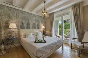 ein Schlafzimmer mit einem großen weißen Bett und einem Stuhl in der Unterkunft Villa Vitae in Castiglione Falletto