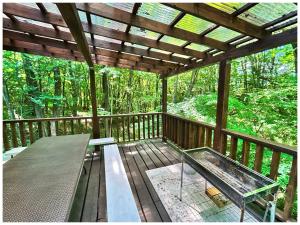 a screened in porch with a table and a roof at コテージちゃ豆ん家 in Nasu