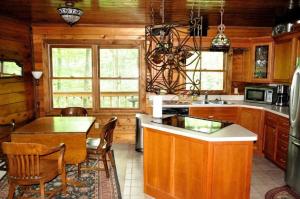 Una cocina con gabinetes de madera y una mesa y sillas. en Wooded & Fabulous Brown County Cabin with Hot Tub Near Nashville, IN, en Nashville