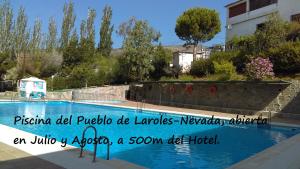 a swimming pool with a sign on the side of it at Hotel Rural Real de Laroles Nevada bike and treeking in Laroles