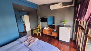 Un dormitorio con una cama, un escritorio y un televisor. en Bigcountry Tour Stay Ayutthaya, en Phra Nakhon Si Ayutthaya