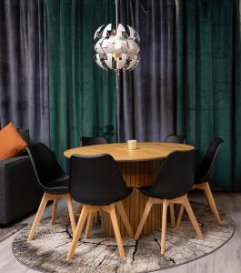 een eettafel met zwarte stoelen en een kroonluchter bij Apartment Haapala A11 in Rovaniemi