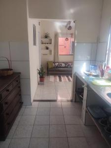 een keuken met een tegelvloer en een kamer met een bank bij Colonial House in Porto Seguro +19 foto's