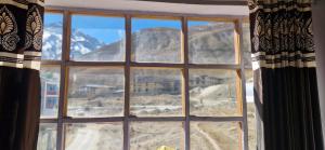 a window with a view of a mountain at Serenity Stay Rangrik in Kaza