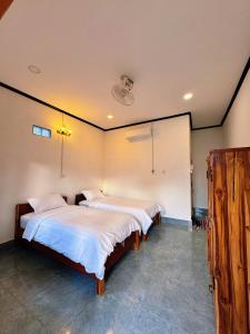 a bedroom with two beds in a room at phoulisack guesthouse in Ban Sôphoun