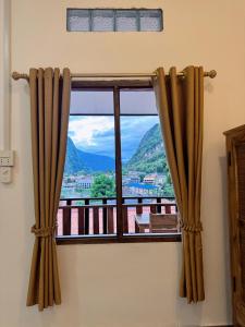 a window with a view of a mountain at phoulisack guesthouse in Ban Sôphoun