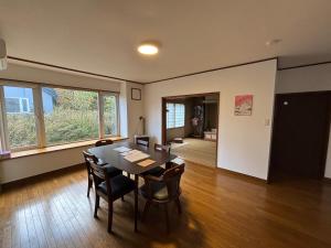 een eetkamer met een tafel en stoelen bij Kamui Adventure House in Asahikawa