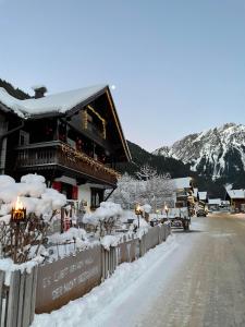 een met sneeuw bedekt gebouw aan een straat met een berg bij Haus Berta, Montafon in Partenen