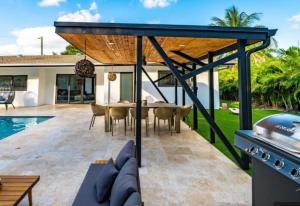 a patio with a table and chairs and a grill at Viva La Villa in Highland Lakes