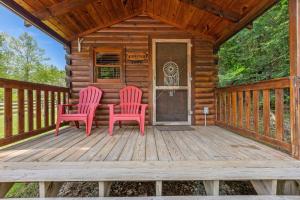 a cabin with two red chairs on a wooden deck at WiFi - Dreamcatcher - Lux-Tiny Cabin in RRG KY in Rogers
