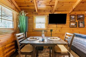 a dining room with a table and chairs in a cabin at WiFi - Dreamcatcher - Lux-Tiny Cabin in RRG KY in Rogers +8 photos