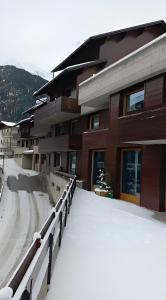 a building with snow on the ground in front of it at Appartamento Viola in Santa Caterina Valfurva