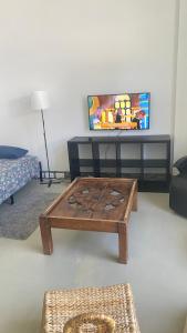 a living room with a coffee table in front of a tv at Red 4 x 4 in Camarma de Esteruelas +7 photos