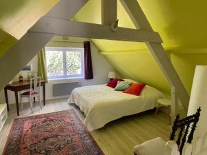 een slaapkamer met een bed, een tafel en een raam bij Holiday home in Houtteville with garden in Picauville