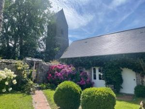 een kerk met een bos bloemen voor een tuin bij Holiday home in Houtteville with garden in Picauville