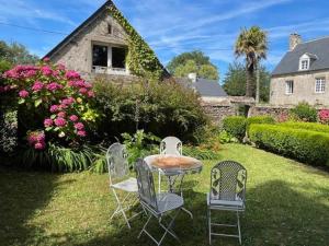 een tafel en stoelen in de tuin van een huis bij Holiday home in Houtteville with garden in Picauville
