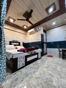 een slaapkamer met een bed en een plafondventilator bij Hotel Raghunandan Inn Near Shri Ram Janmabhoomi in Ayodhya