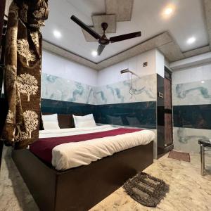 een slaapkamer met een bed met een schilderij aan de muur bij Hotel Raghunandan Inn Near Shri Ram Janmabhoomi in Ayodhya