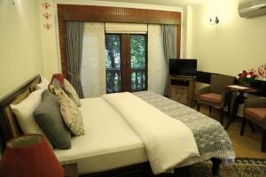 um quarto com uma cama grande e uma janela em The Estate Villa em Nova Deli